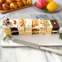 Eight slices of rectangular cake arranged on a ceramic platter.