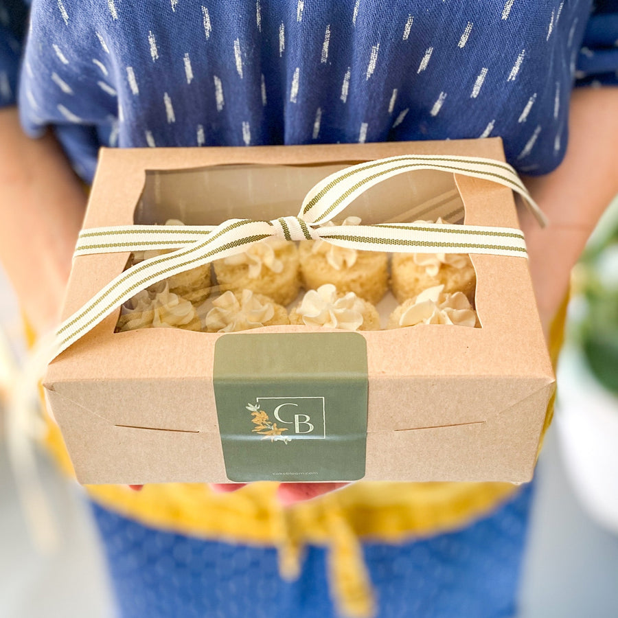 A gift box of bite-sized cakes, tied with a ribbon.